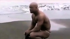 Asian bodybuilder barely covered at the beach